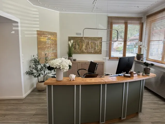 Empfang des Zahnzentrums Hausham mit Holztresen, Blumen und Wandgemälden